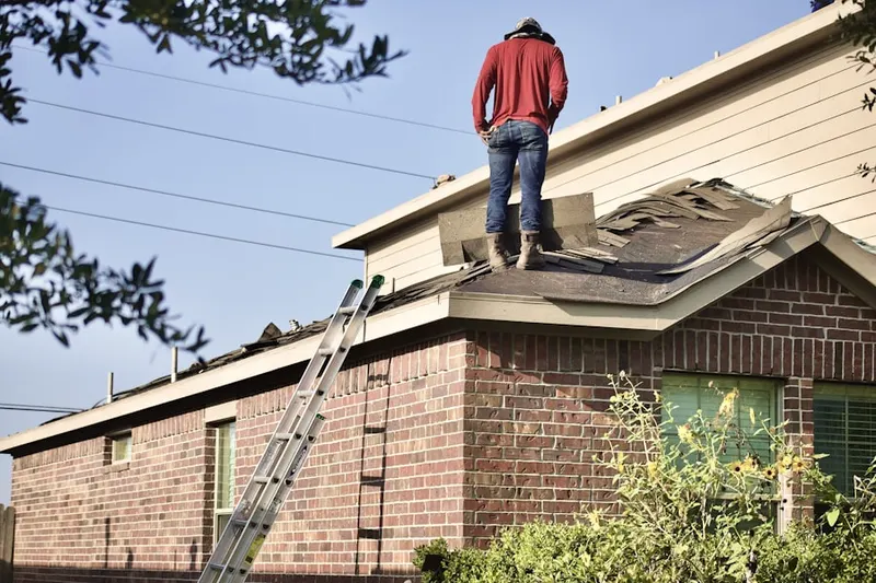 Professional roofer working on a residential roof in Walls